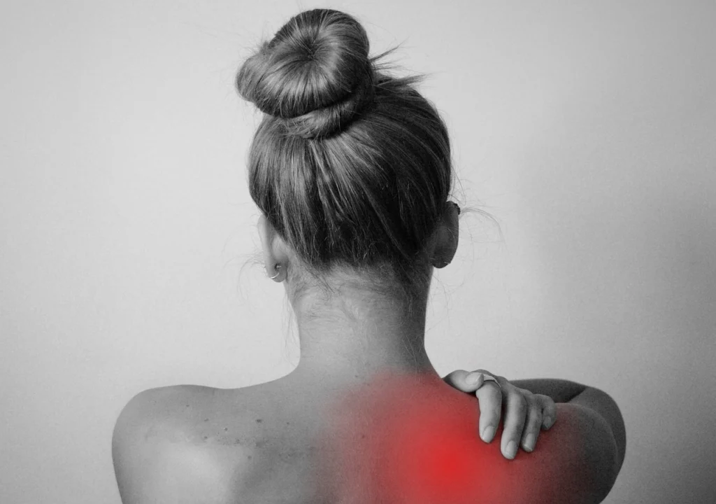 woman in her car rubbing her neck in pain after car accident