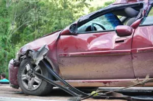 A car with visible damage from a hit-and-run accident on the road
