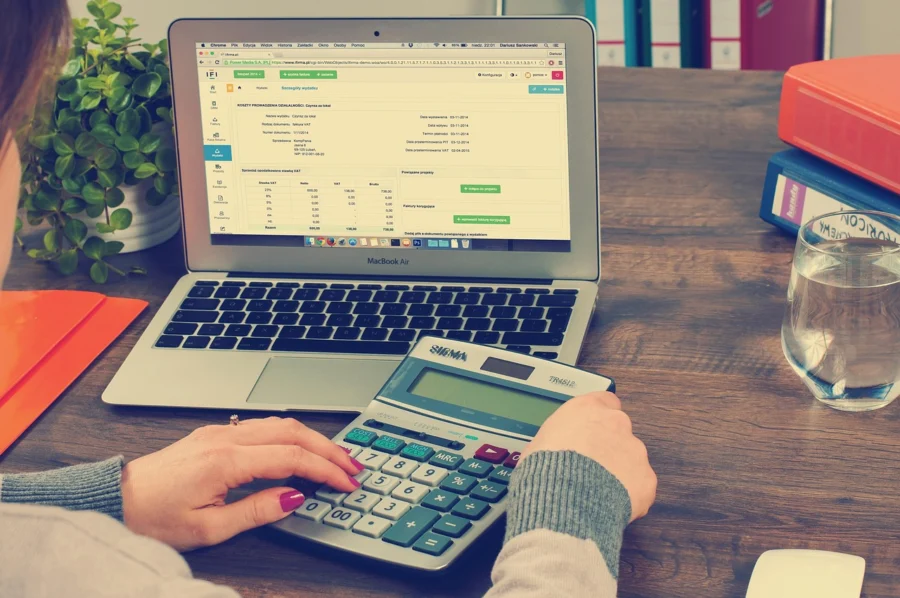 Insurance adjuster calculating pain and suffering damages using a calculator and documents