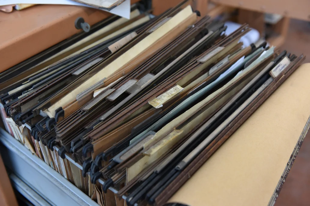 Hands organizing insurance claim documents in a folder