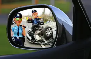 Police officer writing an accident report next to a damaged car